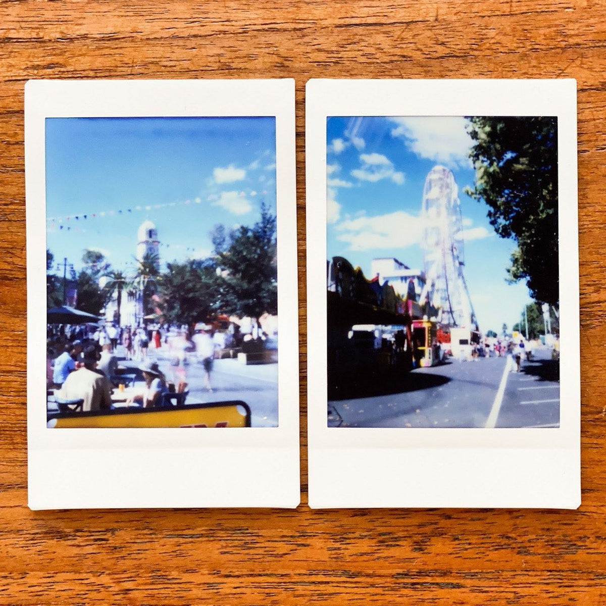 Two instant photos taken with a Jollylook Pinhole Mini camera, placed on a table, capturing the vibrant scenes of an amusement park
