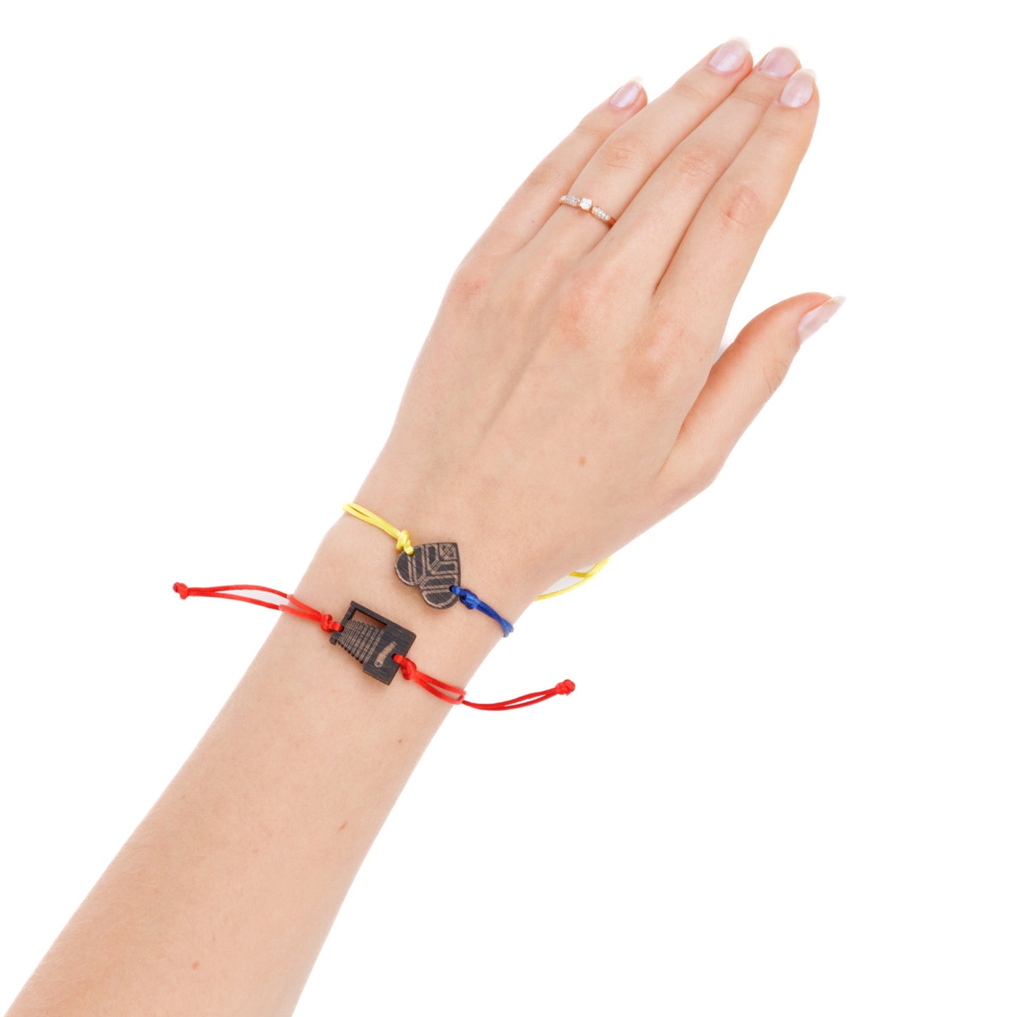 A hand adorned with two colorful bracelets. One bracelet 'Love cameras,' and the other 'Peace for Ukraine.' The hand is against a white background