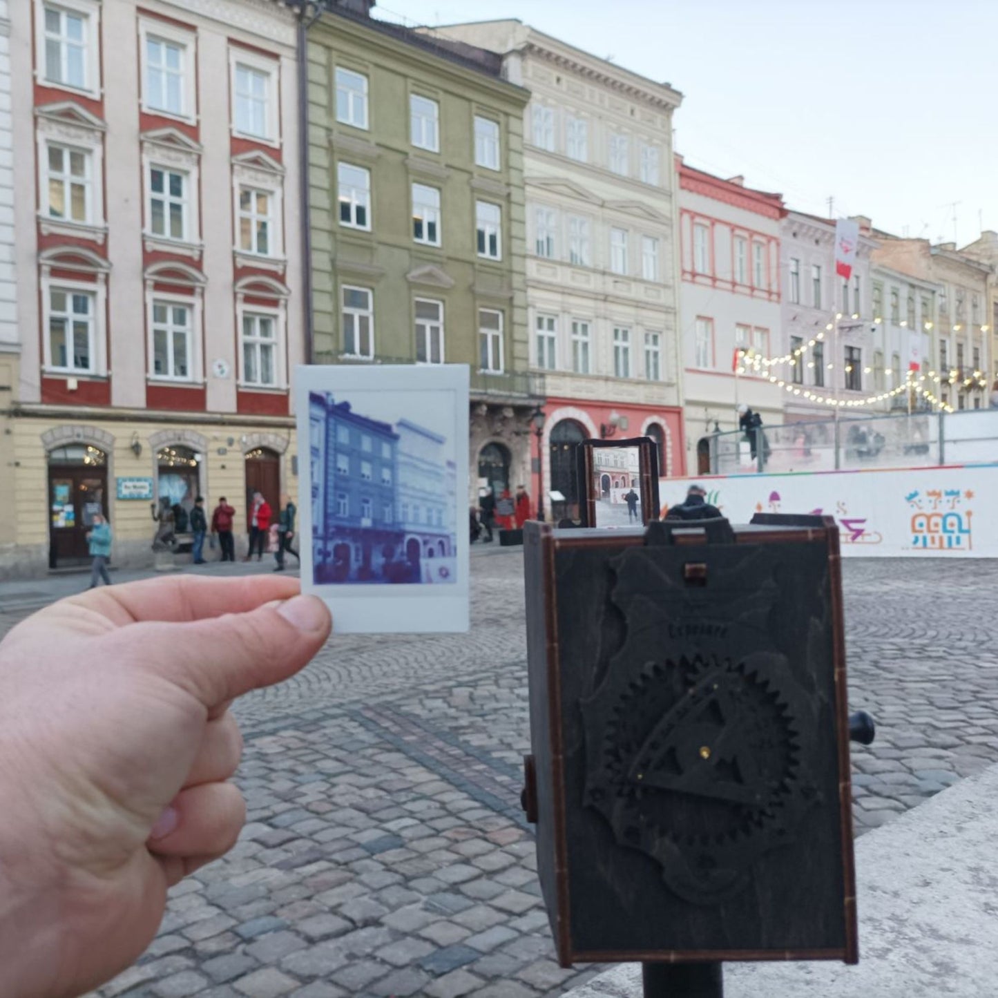 Unfolded Pre-assembled Pinhole Instant Mini Film Camera in Stained Brown Color against the city